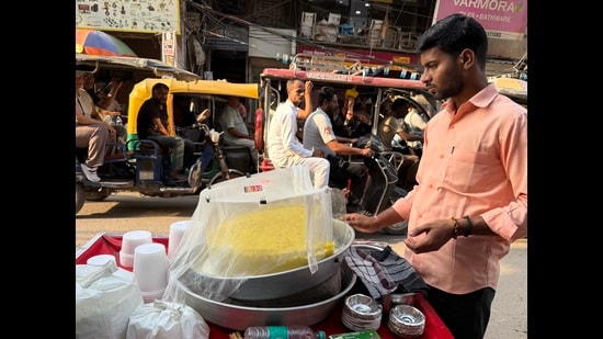 The vendor stands motionless behind a giant platter of daulat ki chaat. (Mayank Austen Soofi)