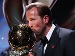 England and Bayern Munich forward Harry Kane kisses the trophy on stage after receiving the Ballon d'Or award for the best male footballer during the 2026 Ballon d'Or France Football award ceremony at the Palladium Theatre in London 