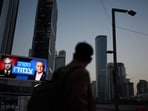 A pedestrian passes a billboard in Tel Aviv, Israel. 