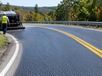 Representative image of a winding roadway treated with a high-friction surface to improve tire grip and reduce wet-weather crashes.(AI-generated)