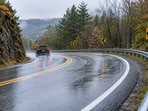 A representaive image of a wet, winding road illustrates the type of crash-prone curves where high-friction surface treatments can improve tire grip and reduce wet-road crashes.
