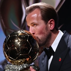 England and Bayern Munich forward Harry Kane kisses the trophy on stage after receiving the Ballon d'Or award for the best male footballer during the 2026 Ballon d'Or France Football award ceremony at the Palladium Theatre in London 