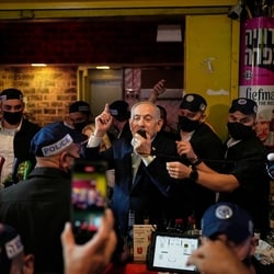 Israeli Prime Minister Benjamin Netanyahu, leader of the Likud party, speaks to supporters during a visit to Jerusalem's Mahane Yehuda Market as part of his election campaign early Friday