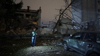 A resident walks at the site of a food production facility hit by a Russian missile strike, amid Russia's attack on Ukraine, in Kyiv. (REUTERS)