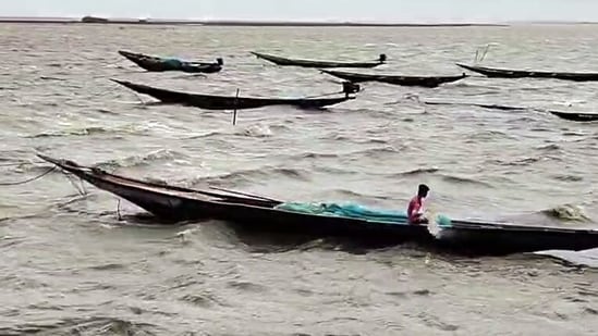 A Fisherman sails his boat amid high tidal waves hitting the coast under the influence of Cyclone Arnab, in Puri on Thursday. (ANI Video Grab)