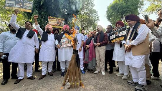 Leader of opposition Partap Singh Bajwa along with Congress MLAs burning brooms to protest against the AAP government outside the Punjab assembly in Chandigarh on Tuesday. (Ravi Kumar/HT)