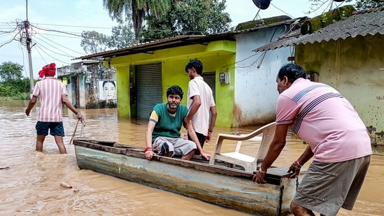 People use a boat to move through a waterlogged area as they leave a flooded low-lying settlement along NH-30 at Donga Ghat following heavy rain caused by Cyclonic Storm Arnab and the release of water from Khatiguda Dam in Odisha, at Jagdalpur, in Bastar district, Chhattisgarh, Sept. 26, 2026.