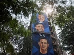 An artist paints a mural featuring Reliance Industries founder Dhirubhai Ambani, Reliance Industries Chairman and Managing Director Mukesh Ambani, and Reliance Jio Infocomm Limited Chairman Akash Ambani. 