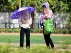 Women wearing scarves walk in a garden on a hot summer day in New Delhi on May 30, 2024, Women wearing scarves walk in a garden on a hot summer day in New Delhi on May 30, 2024,