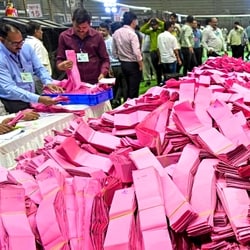 Polling officials handle ballot papers during the counting of votes. 