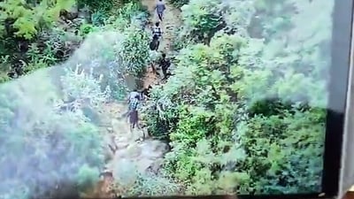 Police use drone surveillance to track down 13 of the 17 inmates who escaped from the Thekkampatti Sub-Jail through dense forested terrain, in Theni on Tuesday. (@SouthZoneTNpol X) Police use drone surveillance to track down 13 of the 17 inmates who escaped from the Thekkampatti Sub-Jail through dense forested terrain, in Theni on Tuesday. (@SouthZoneTNpol X)