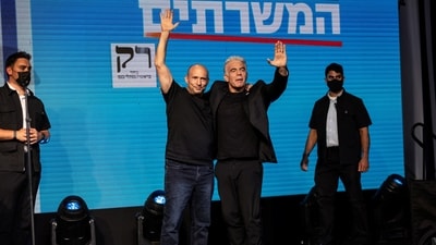 Former Prime Ministers Naftali Bennett and Yair Lapid gesture following exit polls in Tel Aviv, Israel. (REUTERS)