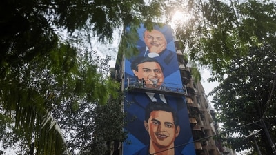 An artist paints a mural featuring Reliance Industries founder Dhirubhai Ambani, Reliance Industries Chairman and Managing Director Mukesh Ambani, and Reliance Jio Infocomm Limited Chairman Akash Ambani. (Representative Image/Reuters)