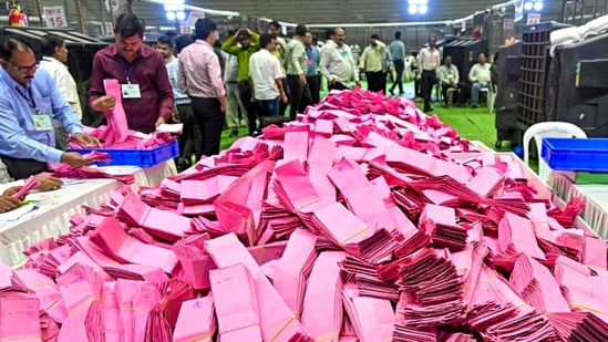 Polling officials handle ballot papers during the counting of votes.