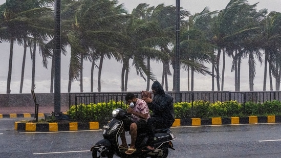 Visakhapatnam: Commuters wade ahead of the impending landfall of cyclonic storm 'Arnab'.