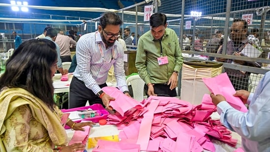 Polling officials handle ballot papers during the counting of votes for the Maharashtra Legislative Council election in Nagpur.