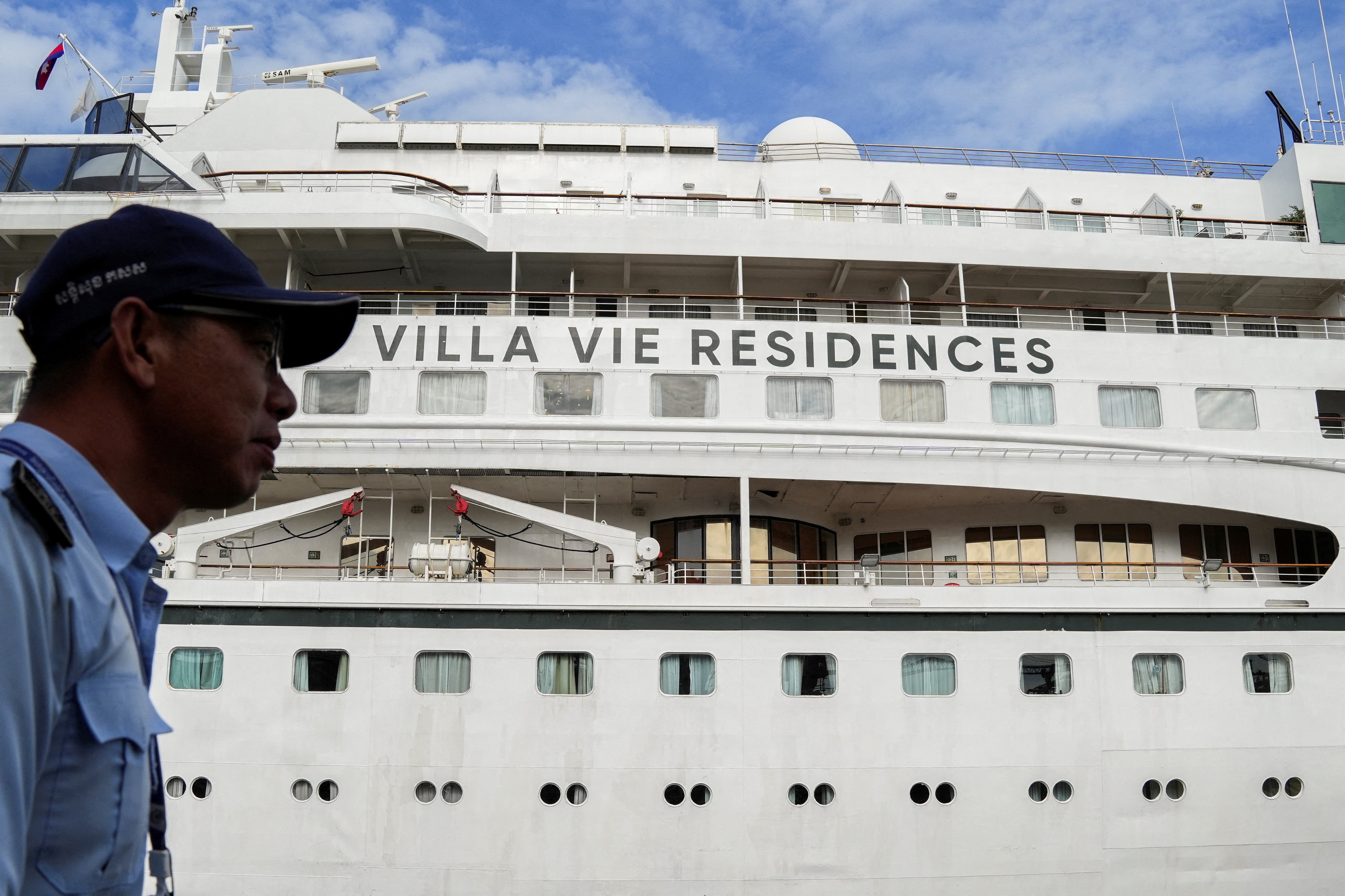 A security staff member stands guard near the Villa Vie Odyssey cruise ship docking at Sihanoukville Autonomous Port, after permanent residents living aboard the vessel were forced to disembark in Cambodia (REUTERS)