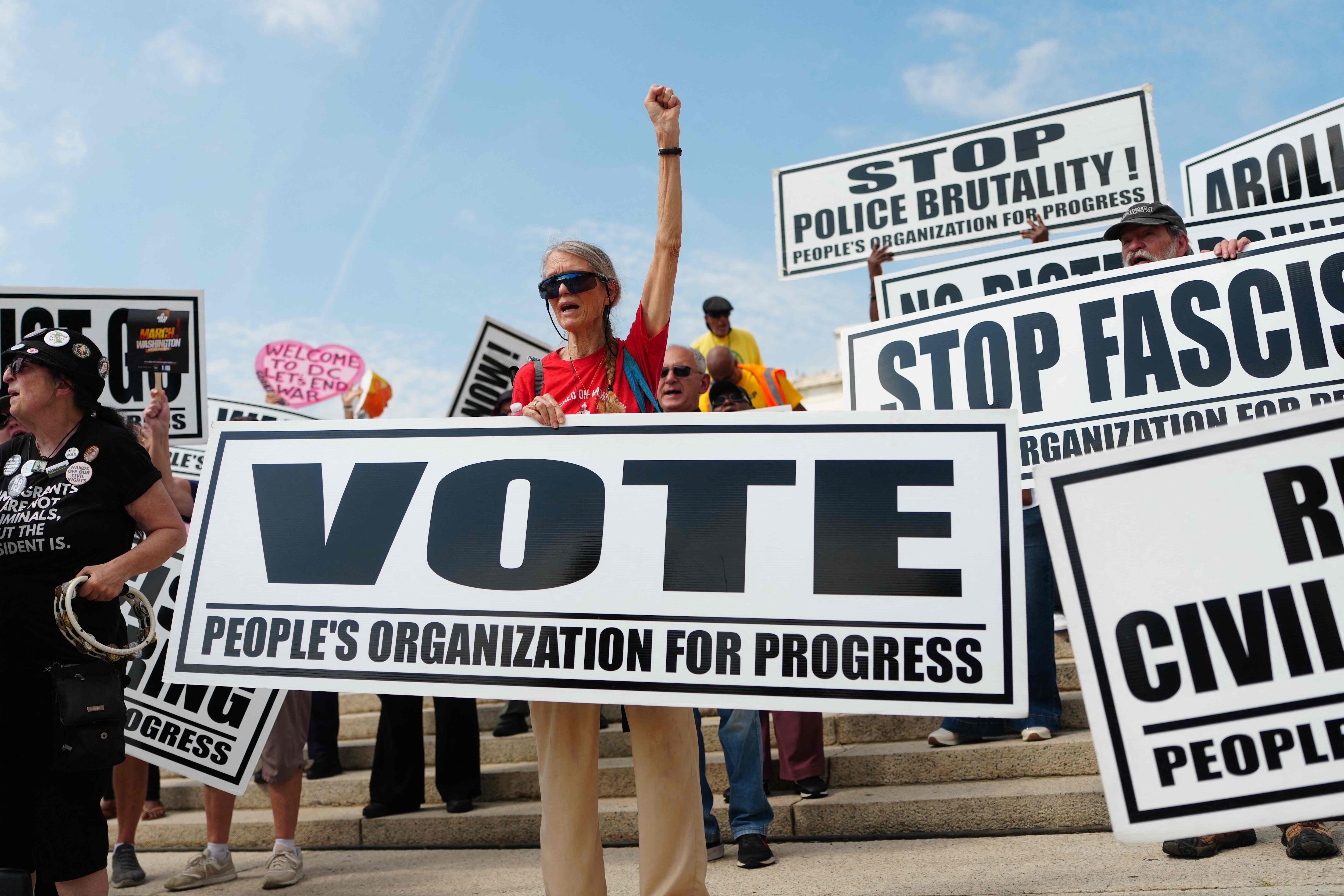 A woman holds a 'Vote' sign during the 'Defend the Vote' rally at the Lincoln Memorial in Washington, DC, on August 28, 2026, ahead of the US midterm elections. (AFP) (AFP)