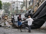 A man walks past the destruction caused at Kakinada, India, after Cyclone Arnab crossed the Andhra Pradesh coast.