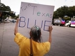 A woman holds a 'Turn Texas Blue' sign during early voting ahead of the November 3 US midterm elections, in Austin.