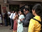 Voters stand in a queue at a polling booth at NMC Hindi School, Vivekanand Nagar (ANI Video Grab)