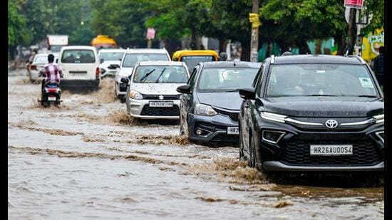 Vehicles wade through a waterlogged stretch of Sector 10 Road on Friday (Parveen Kumar/HT)